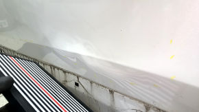 Ușa stângă față a unui Honda CRV 17-22, albă, NH-883P, este îndoită, are lovituri și zgârieturi.