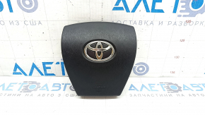 Airbag-ul lateral al șoferului din volanul unui Toyota Prius V 12-17 este negru și zgâriat.