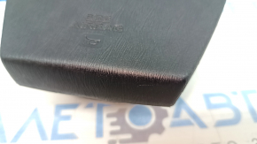 Airbag-ul lateral al șoferului din volanul unui Toyota Prius V 12-17 este negru și zgâriat.