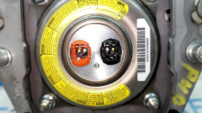 Airbag-ul lateral al șoferului din volanul unui Toyota Prius V 12-17 este negru și zgâriat.