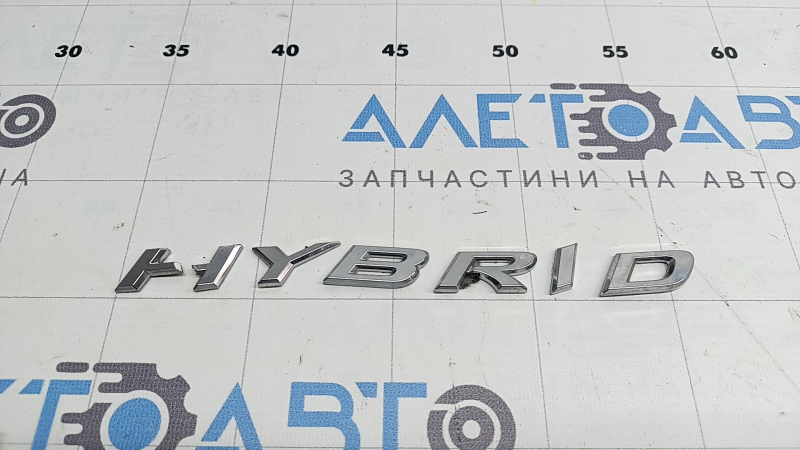 Emblema cu inscripția HYBRID de pe ușa spate dreapta a unui Lexus UX250h 19-22 este ruptă. Litera „H” este ruptă.